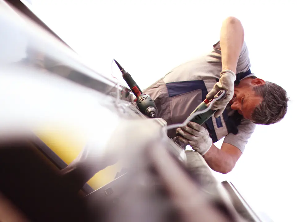 Roofer fixing a fascia board at the eaves