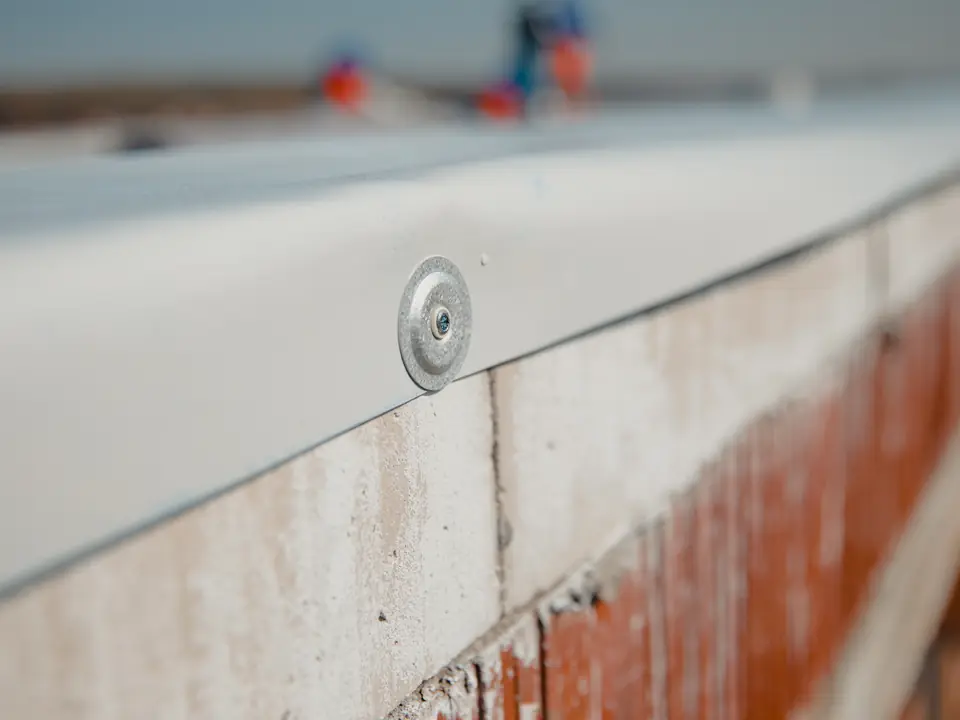 Membrane turned over the edge trim of a flat roof