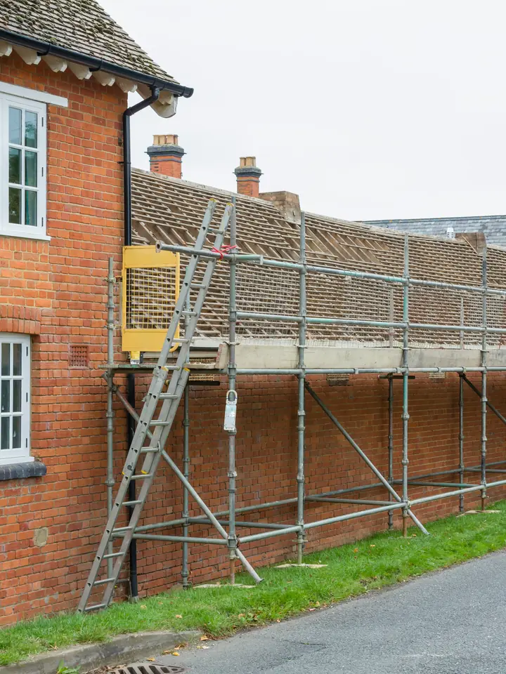 Scaffolding along a brick terrace ready for a new roof