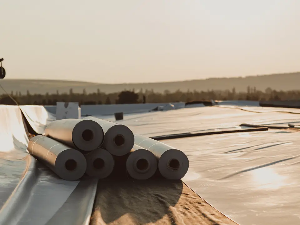 Rolls of single-ply membrane ready on a flat roof